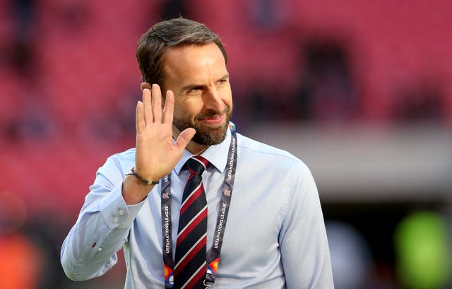 Gareth Southgate, dressed in a shirt and tie, waving 