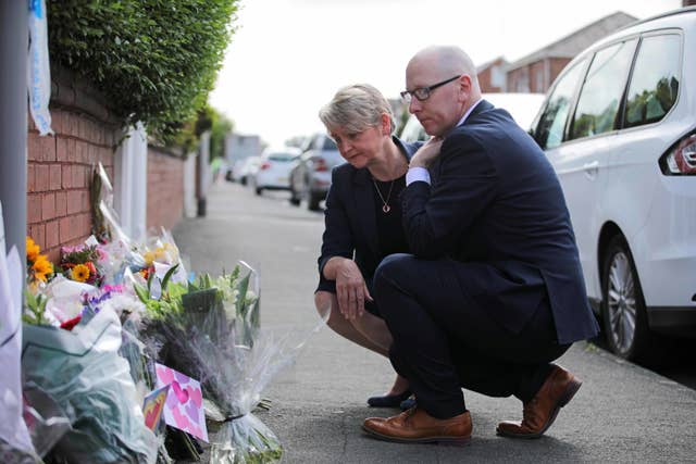 Home Secretary Yvette Cooper and Patrick Hurley, the Labour MP for Southport, look at tributes laid near to the knife attack that left three children dead