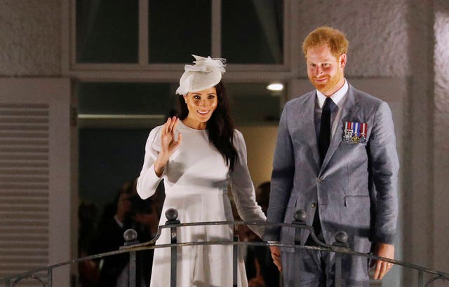 Meghan and Harry on the balcony of the Grand Pacific Hotel