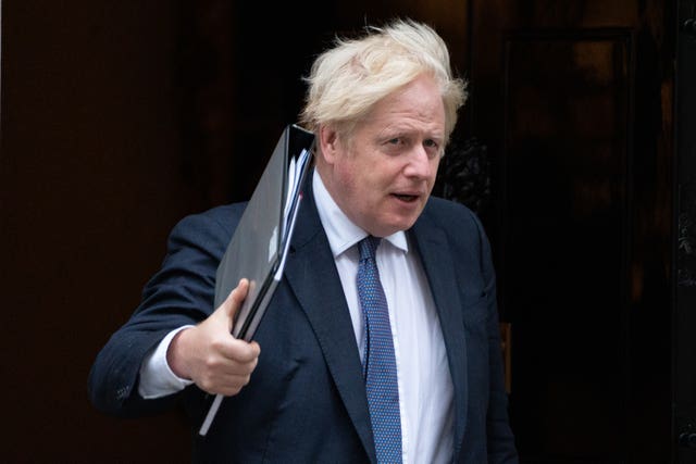 Prime Minister Boris Johnson leaves 10 Downing Street holding a binder