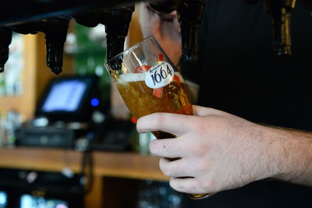 A bar tender pours a Kronenbourg beer in a pub in Fulham, London