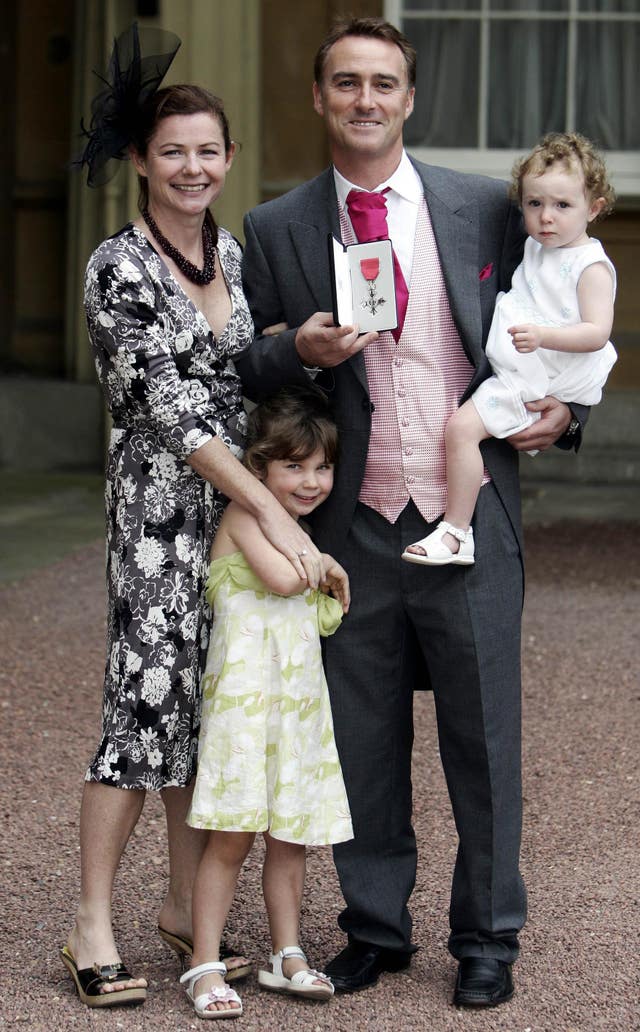 Graham Thorpe, centre, receives his MBE in 2007 accompanied by his wife Amanda, left, and daughters Kitty, front, and Emma, right, in Graham's arms