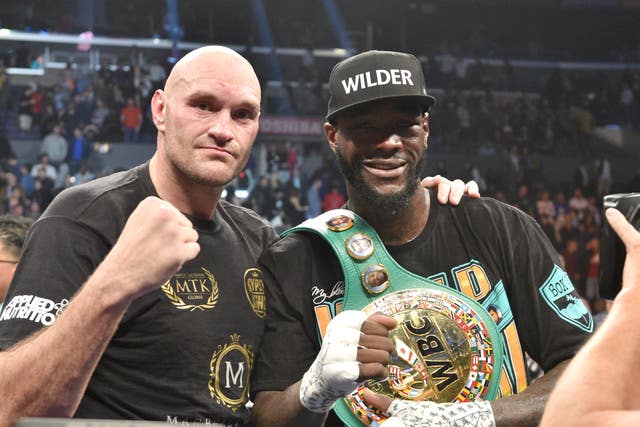 Deontay Wilder, right, and Tyson Fury pose for photographs after their first fight