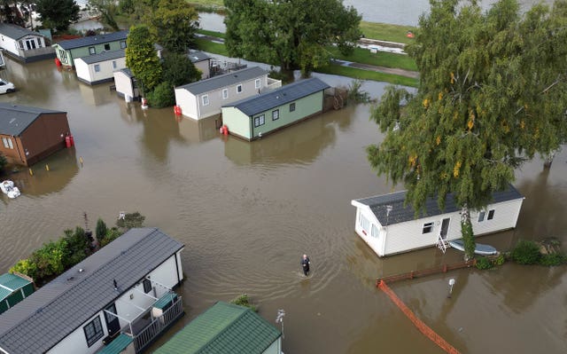 A man wades through floodwater at Cogenhoe Mill holiday park in Northamptonshire, which is next to Billing Aquadrome holiday park. 