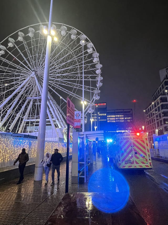 An ambulance next to a Ferris wheel