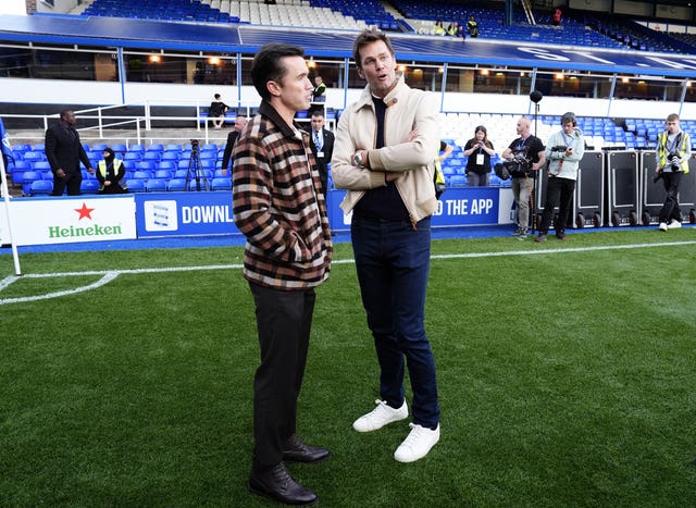 Wrexham co-owner Rob McElhenney, left, and Birmingham co-owner Tom Brady talk before a game