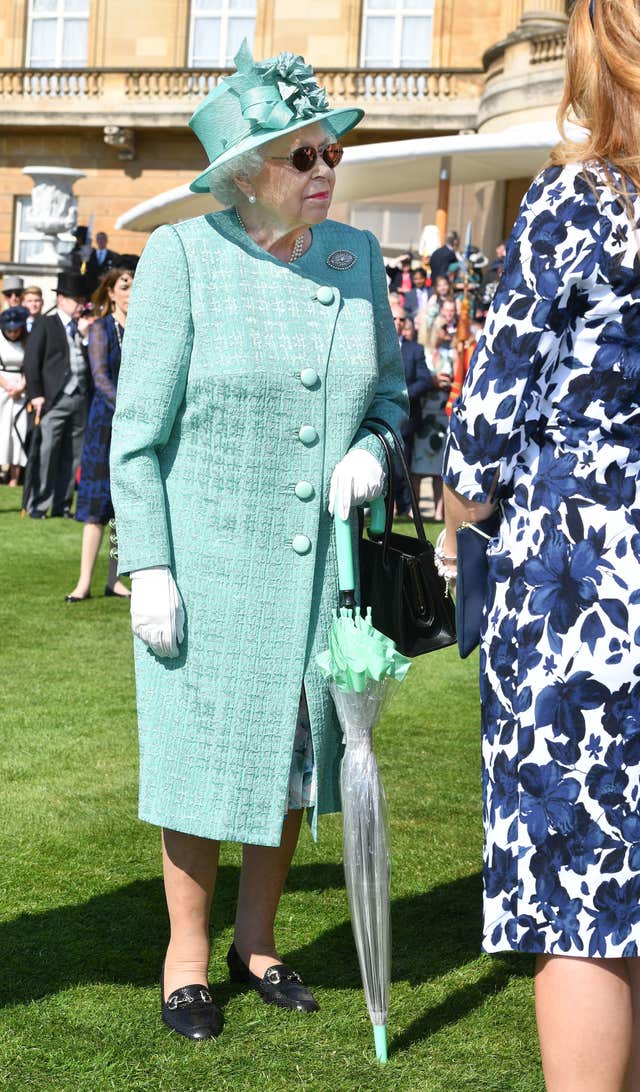 The Queen held on to an umbrella at the garden party (John Stillwell/PA)