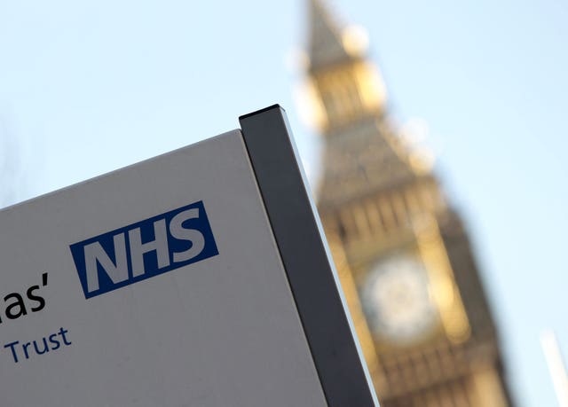 An NHS sign in the foreground, in front of a blurred Big Ben