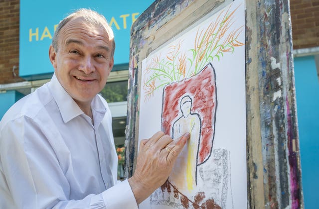Liberal Democrat leader Sir Ed Davey drawing a charcoal on pastel artwork at Harrogate College