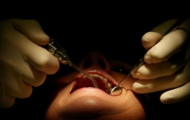 Private Dentist Doctor Gregory Foster performs a routine check-up at his practice in Greater Manchester