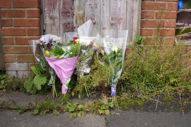 Flowers left outside Donald Patience's property on Ainsworth Road (Peter Byrne/PA)