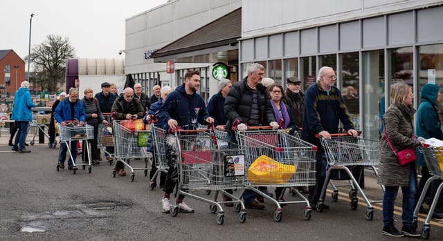 People queue to shop at a Sainsbury’s supermarket in Leamington Spa, Warwickshire