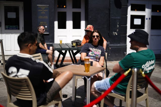 Oasis fans sitting at tables having a drink outside a pub