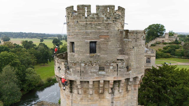 Warwick Castle as two abseiling workers clean the brickwork