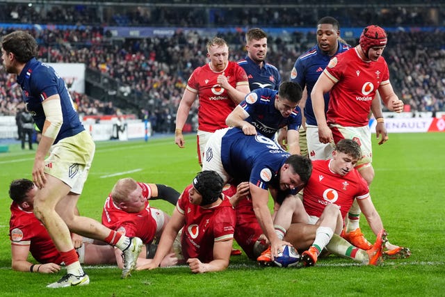 France’s Julien Marchand (centre right) dives over his opponents to score a try against Wales