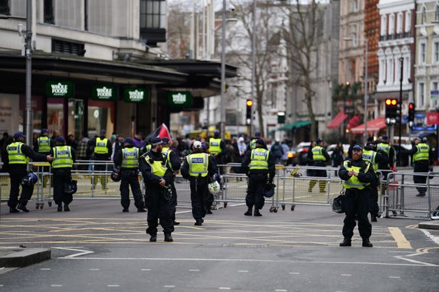 Several police officers manning barriers on a road