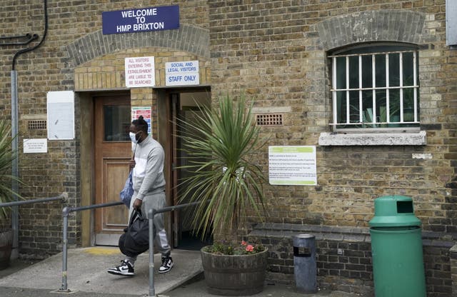 A person leaving HMP Brixton, holding a black bag