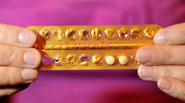 A woman holding a pack of contraceptive pills