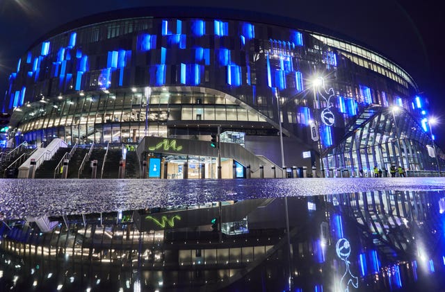 The outside of The Tottenham Hotspur Stadium is reflected in standing water