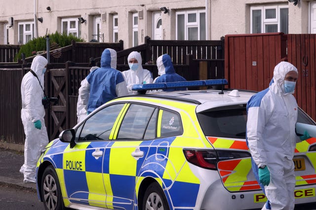 Forensic officers next to a police car