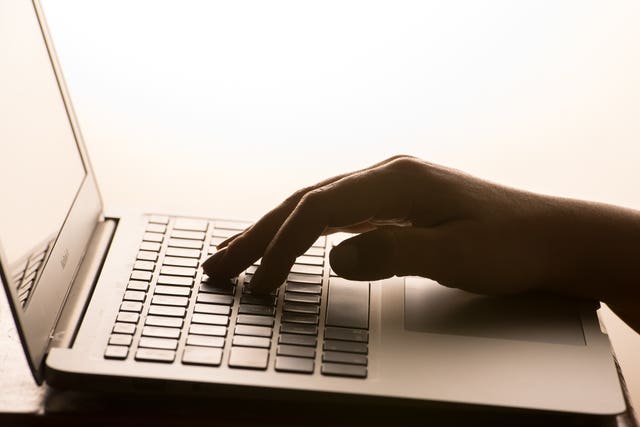 A woman's hands on a laptop keyboard