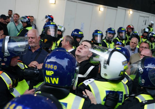 Police officers scuffle with people attending protest in Whitehall on Wednesday