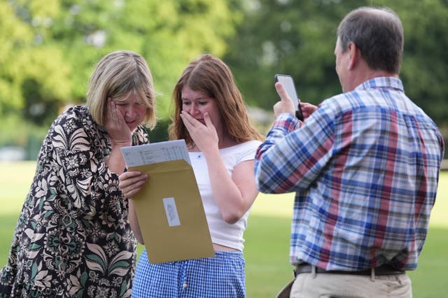 Hannah Greenwood reacts with her parents after receiving her A-level results at Solihull School in the West Midlands