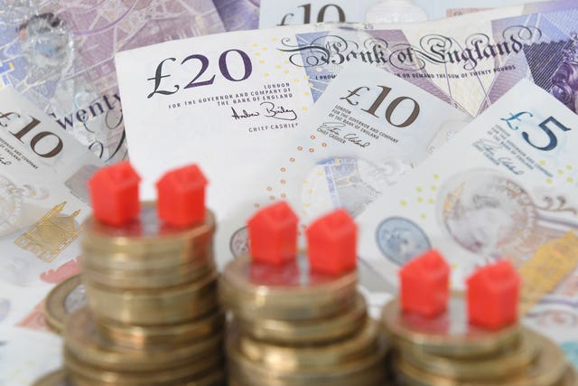 Monopoly houses on top of a pile of pound coins