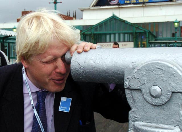 Boris Johnson looks through a telescope on the North Pier at Blackpool (Archive/PA)