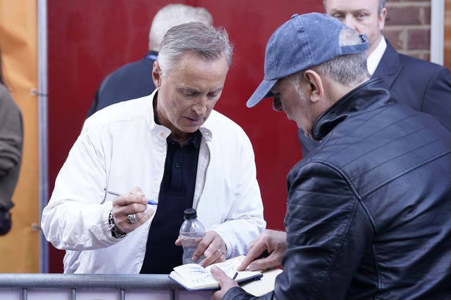 Robert Carlyle signs an autograph for a fan as he attends the premiere 