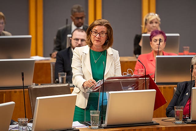 Eluned Morgan standing while speaking in the Welsh Parliament