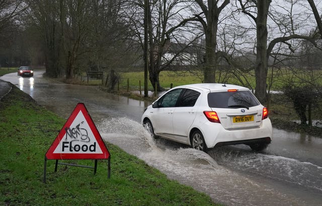 A car passes through a flooded road in Ashford, Kent, in the aftermath of Storm Chandra 