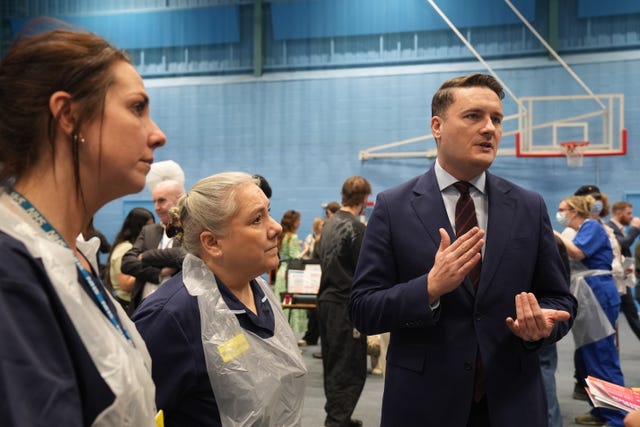 Wes Streeting speaking while standing amongst health workers