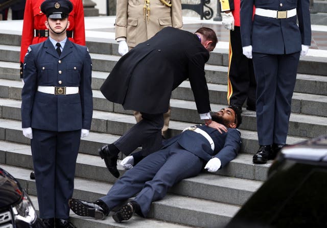 A guardsman faints ahead of the service 
