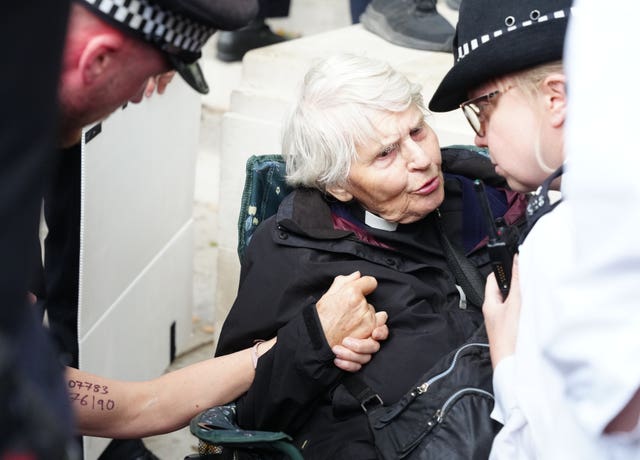 Metropolitan Police officers speaking to Reverend Sue Parfitt during a protest in support of Palestine Action