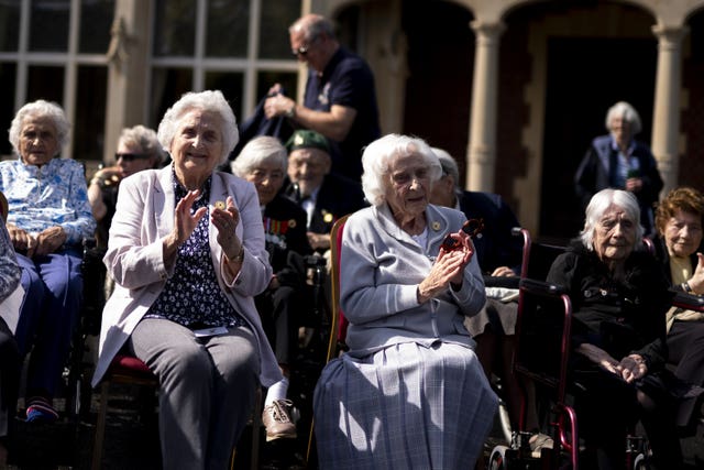 Veterans Ruth Bourne (left) and Charlotte Webb (center right) infront of Bletchley Park Mansion, as they return to the scene of their wartime service at the annual Bletchley Park reunion