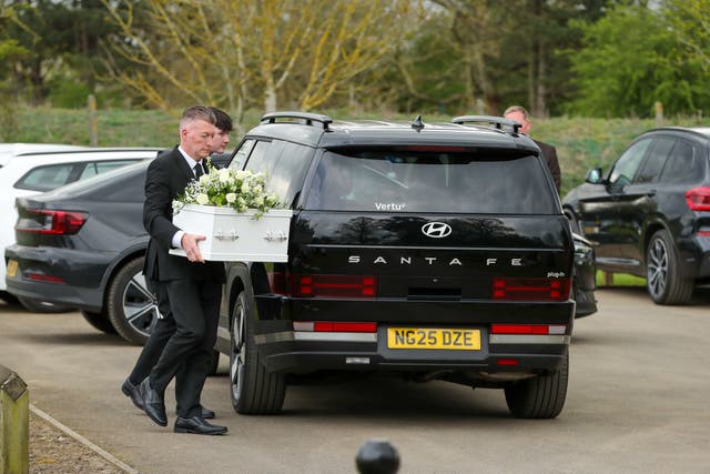 A coffin is carried at the Baby Auckland funeral