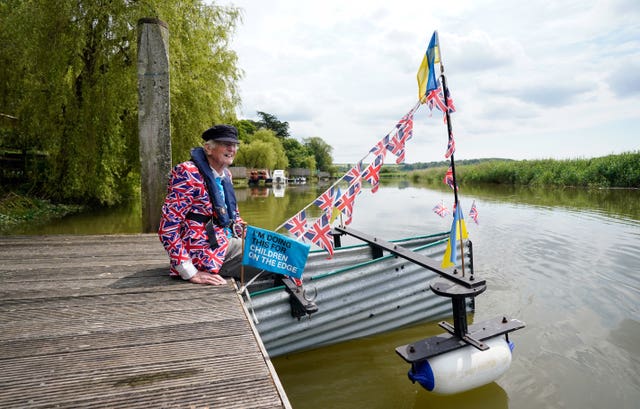 Michael Stanley sitting next to his boat during the launch of his new Tintanic rowing challenge at the Black Rabbit pub near Arundel