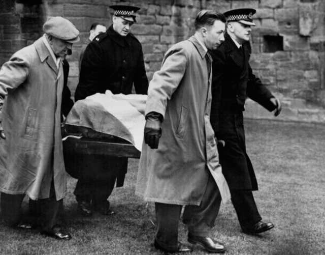 Black and white photo of two police officers in uniform and two other men carrying the Stone of Destiny