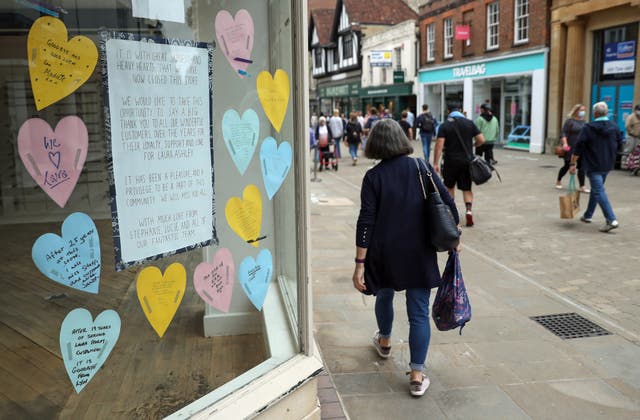 People walk past a closed down Laura Ashley shop, with messages from staff and customers in the shop window, on the high street in Winchester, Hampshire, some six months on from the evening of March 23 when Prime Minister Boris Johnson announced nationwide restrictions 