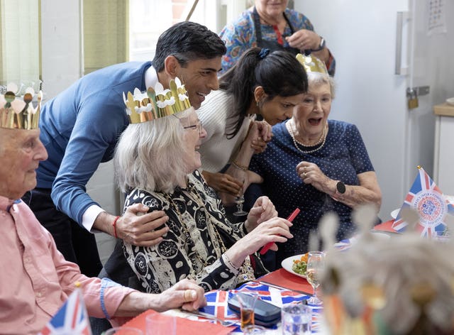 Prime Minister Rishi Sunak and his wife Akshata Murty speak to members of a community group’s lunch club at Mill End Community Centre, Rickmansworth, as part of the Big Help Out