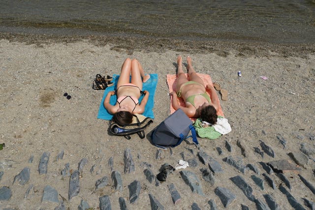 Sunbathers at Loch Lomond, in the village of Luss in Argyll and Bute, Scotland