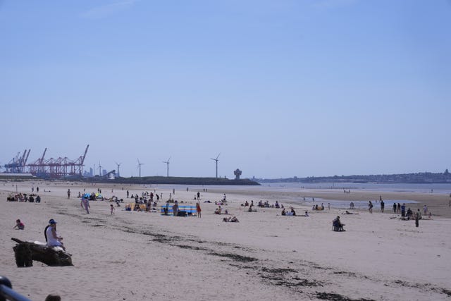 People enjoy the hot weather on Crosby Beach in Merseyside
