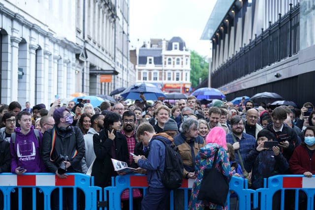 Crowds wait in line to board the first Elizabeth line train to carry passengers at Paddington station, London