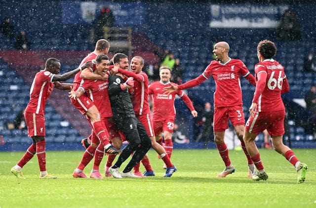 Liverpool players celebrate with goalkeeper Alisson Becker after he scored the winner at West Brom