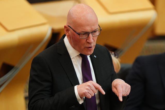 John Swinney pointing while speaking in Parliament