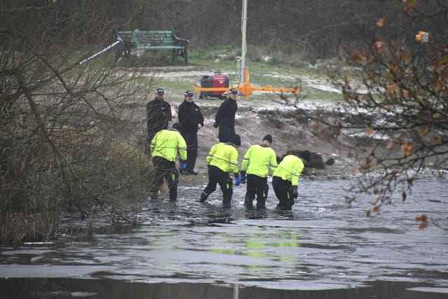 Police search teams at the scene in Babbs Mill Park in Kingshurst, Solihull where three children died after falling through ice 