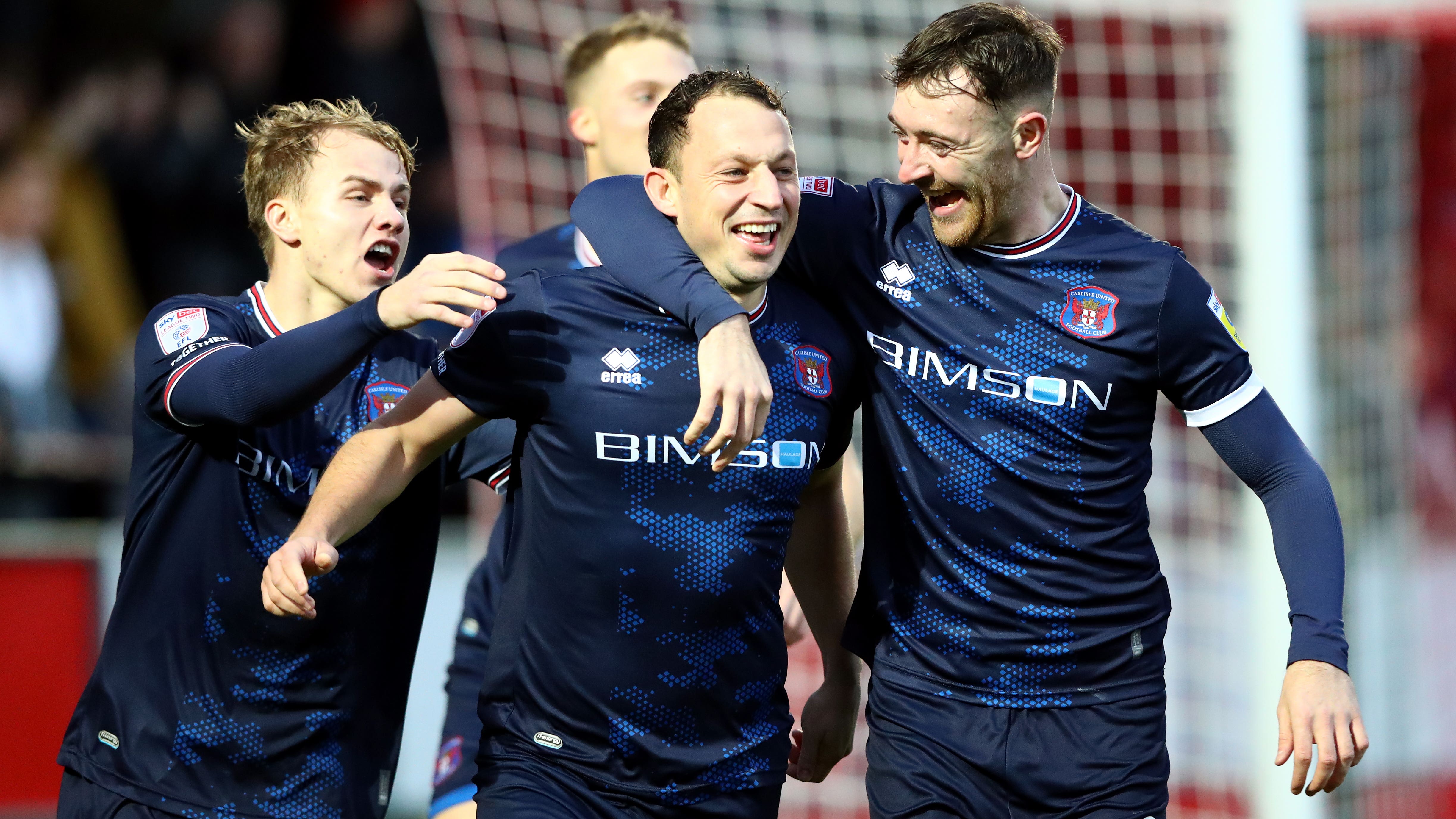 Kristian Dennis, centre, scored twice for Carlisle (Tim Markland/PA)