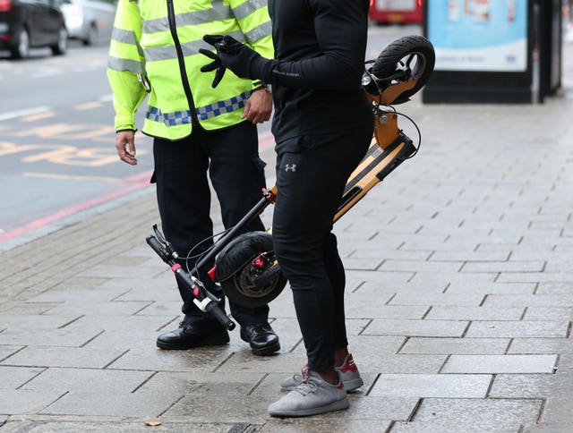 An e-scooter rider being stopped by a police officer