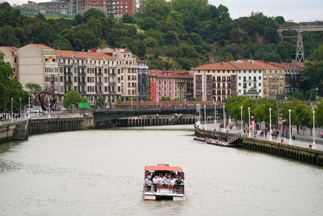 A boat full of Tottenham Hotspur fans heads down the Nervion River in Bilbao 
